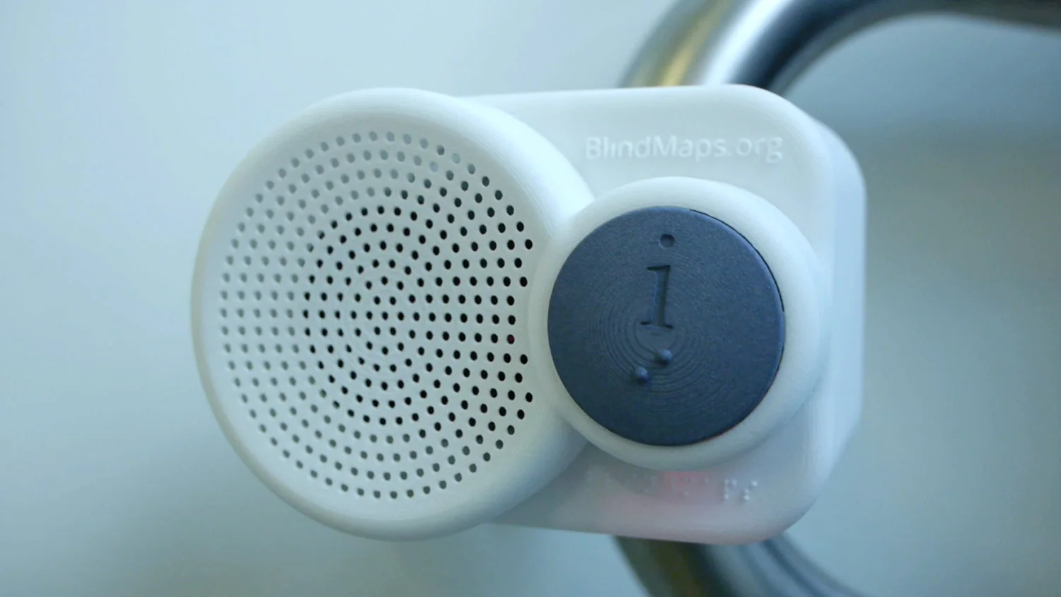 A BlindMaps audio beacon attached to a station handrail